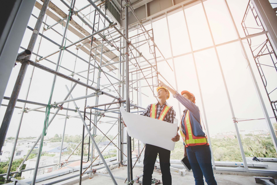 People with plans at construction site