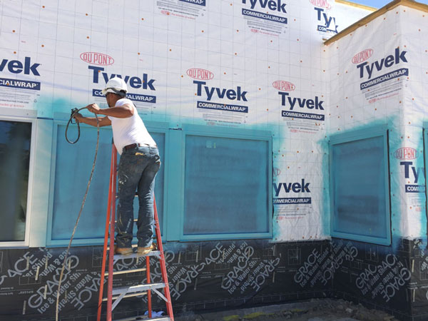 Worker installing window protect on worksite